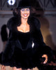 Smiling model in a black fur coat and hat on the runway - HerAge